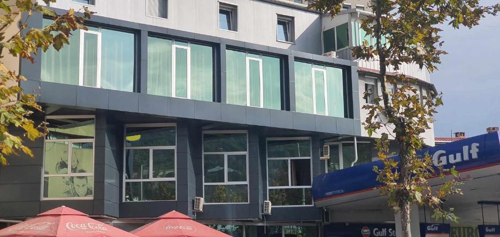 un edificio alto con ventanas de cristal delante de él en E & P Hotel 2, en Tetovo