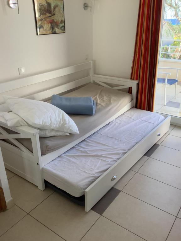 Ce lit superposé blanc se trouve dans un dortoir doté d'une fenêtre. dans l'établissement La perle de lozari, Duplex vue mer, Belgodère, L'île rousse, Corse, à Belgodère