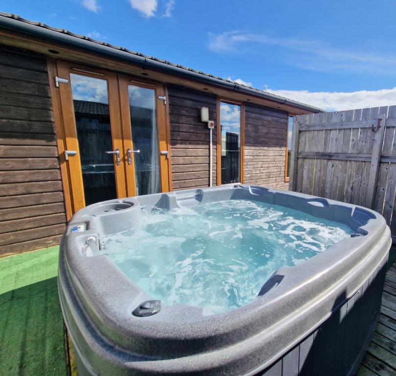 einen Whirlpool auf der Terrasse eines Hauses in der Unterkunft Cleish 7 With Private Hot Tub - Fife - Loch Leven - Lomond Hills - Pet Friendly in Kelty