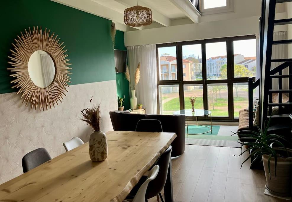 - une salle à manger avec une table en bois et un miroir dans l'établissement Appart vue port, proche océan, à Les Sables-dʼOlonne