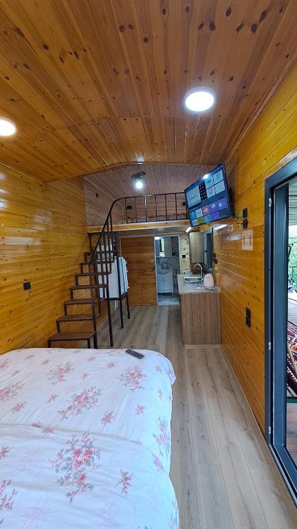 Una habitación con una cama y una escalera en una casa en HAN Tiny House, en Akcaabat