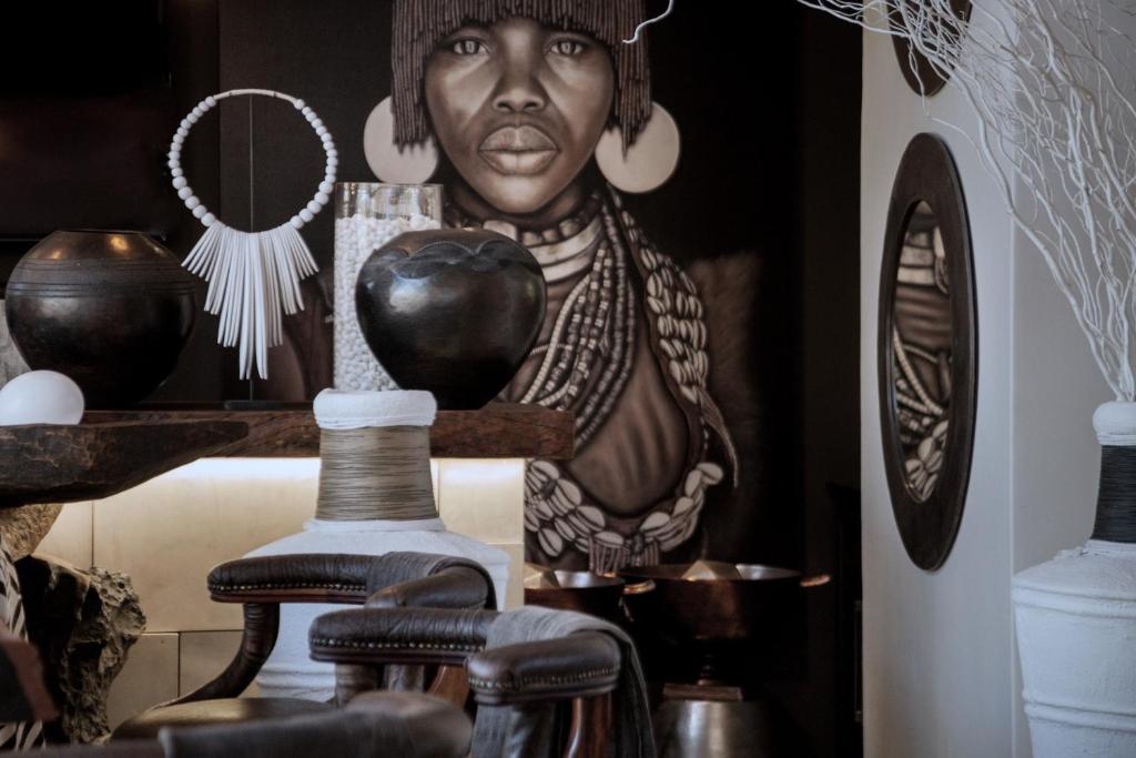 a painting of a woman on a wall with vases at African Flair Boutique Safari Lodge in Hoedspruit