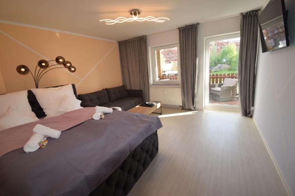 ein Schlafzimmer mit einem Bett, einem Sofa und einem Fenster in der Unterkunft Bliss Place - 1R Premium Apartment - Kingsize Bett, Smart TV, Küche, Balkon, Waschkeller in Magdeburg