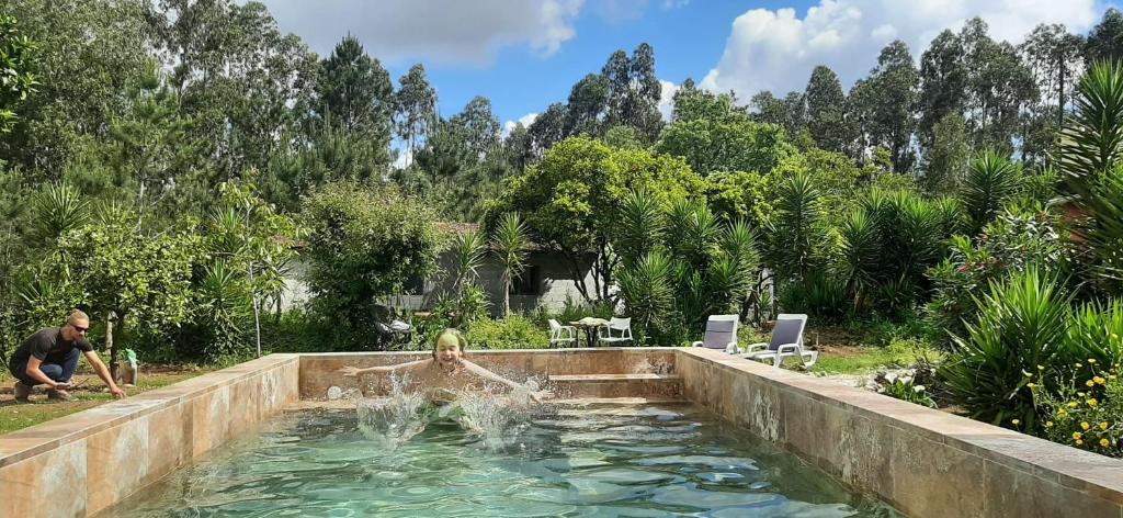 una mujer nadando en una piscina en un patio trasero en Guesthouse & Mini camping Yuccasa, en Pombal