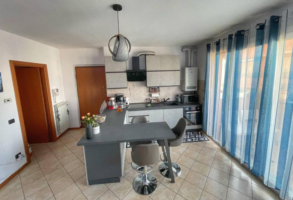 una cocina con isla en medio de una habitación en Lussuoso Bilocale con parcheggio gratuito, en Rovello Porro