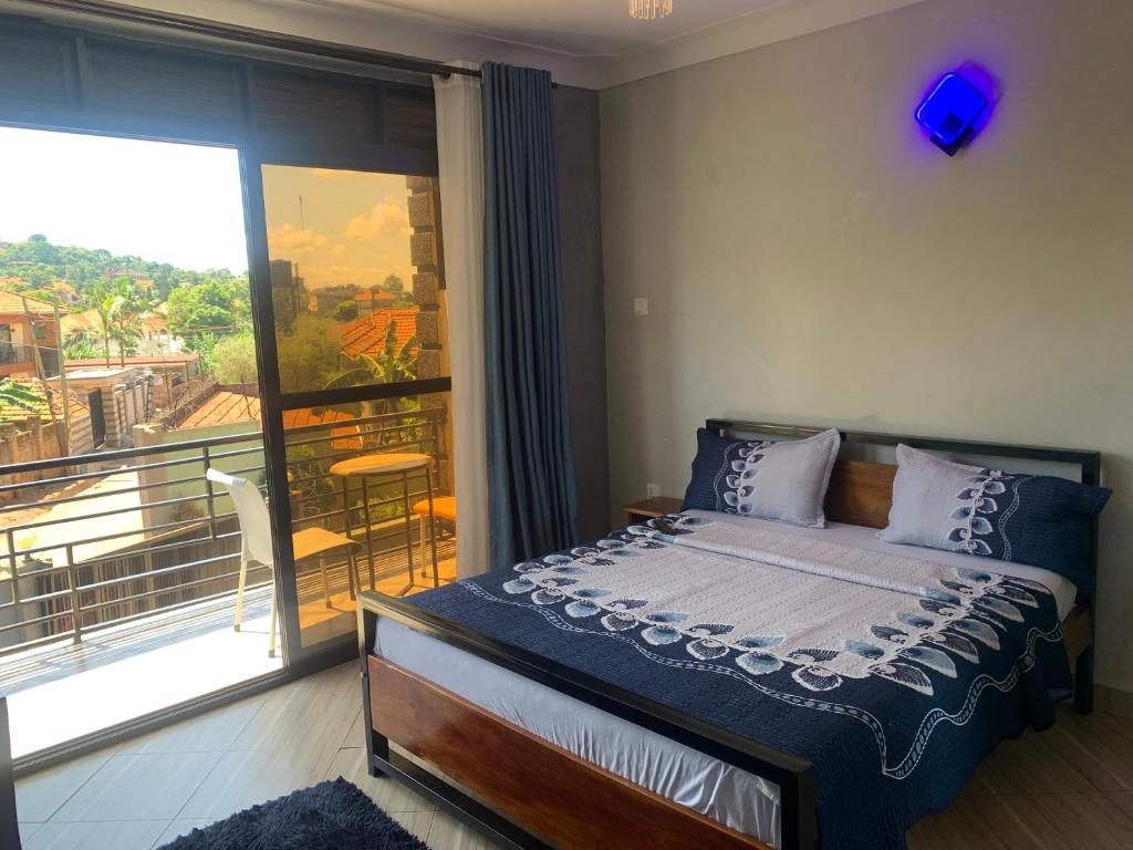 a bedroom with a bed and a balcony at xfurnishedapartments in Kampala