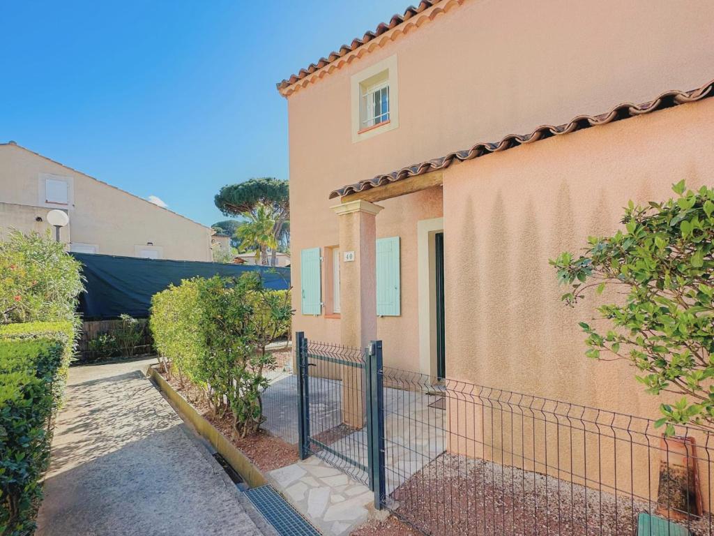 a house with a fence in front of it at Petite villa au calme dans résidence avec piscine in Fréjus