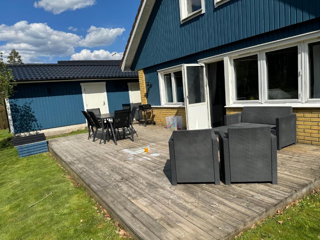 a patio with chairs and a table in front of a house at Family Friendly Villa 15 min from Ullared in Älvsered