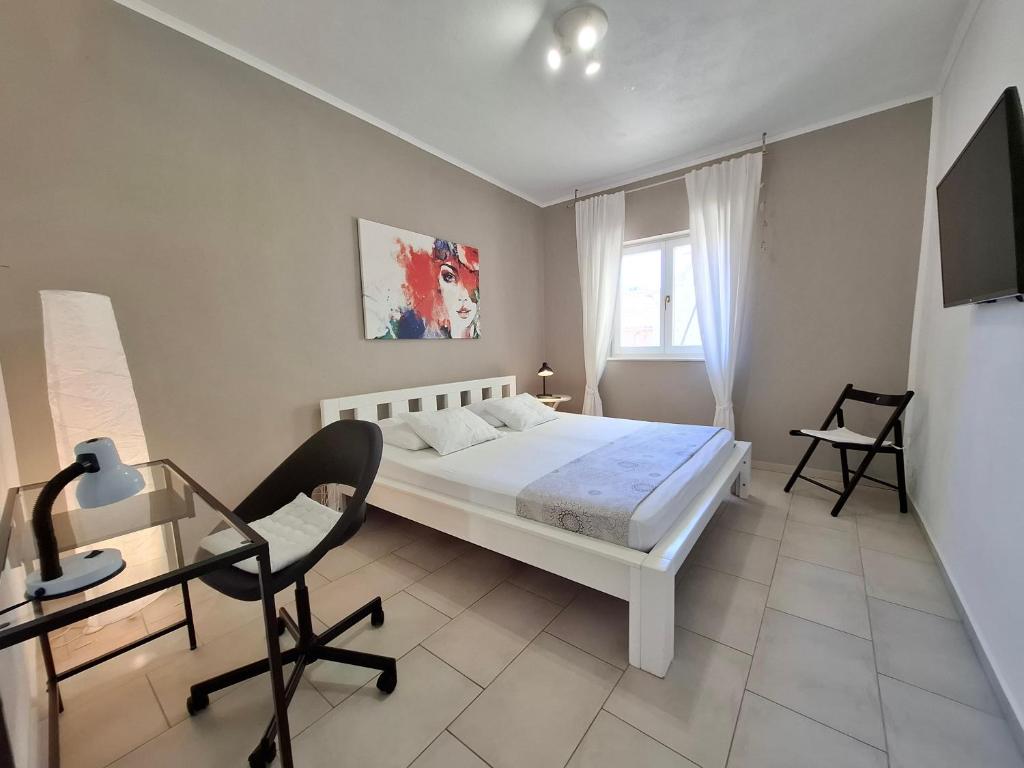 a bedroom with a bed and a desk and a window at Apartment Sandy in Hvar