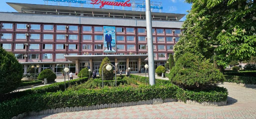 un gran edificio con un edificio con un cartel en Dushanbe Hotel en Dushanbe