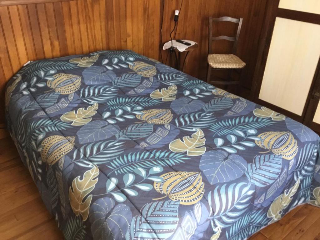 Ce lit se trouve dans un dortoir doté d'une couverture bleue et jaune. dans l'établissement Logement avec parking max 7 personnes, à Eauze