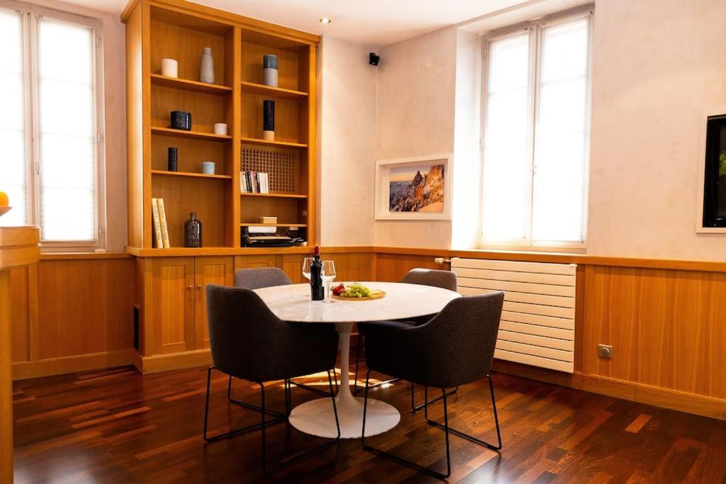 une salle à manger avec une table et des chaises blanches dans l'établissement Appartement Annecy centre historique parking réservé, à Annecy