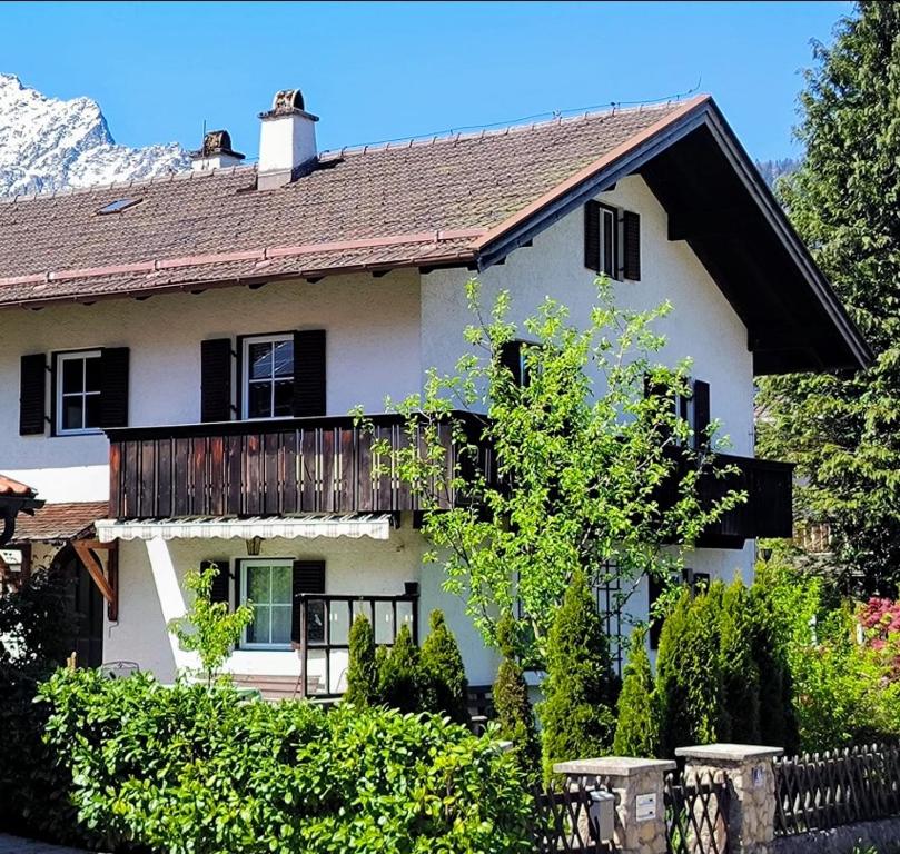 Cette maison blanche dispose d'un balcon. dans l'établissement Ferienwohnung Straußstrasse, à Bayerisch Gmain