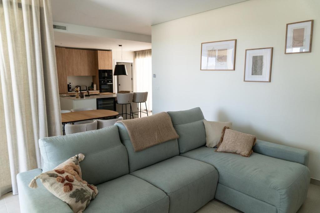 uma sala de estar com um sofá azul e uma cozinha em Villa Fidel Murcia em Múrcia