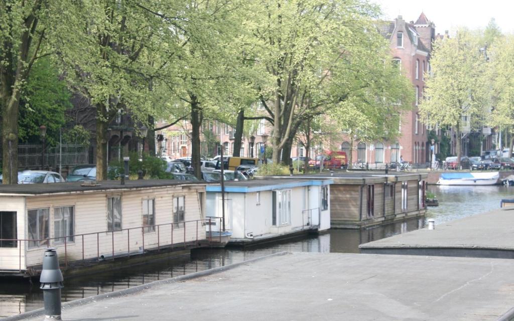 une rangée de maisons sur un canal dans une ville dans l'établissement HouseBoat, à Amsterdam