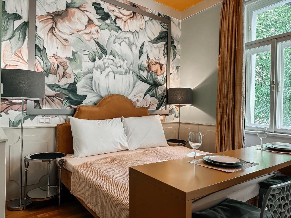ein Schlafzimmer mit einem Bett mit einem Blumenbild an der Wand in der Unterkunft ELSO Muzeum apartments in Prag