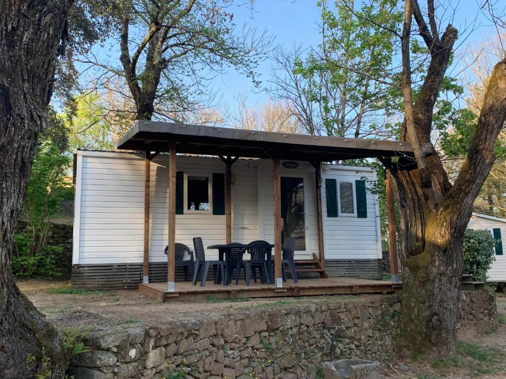een huis met een veranda met een tafel en stoelen bij Camping Les Cruses in Ribes