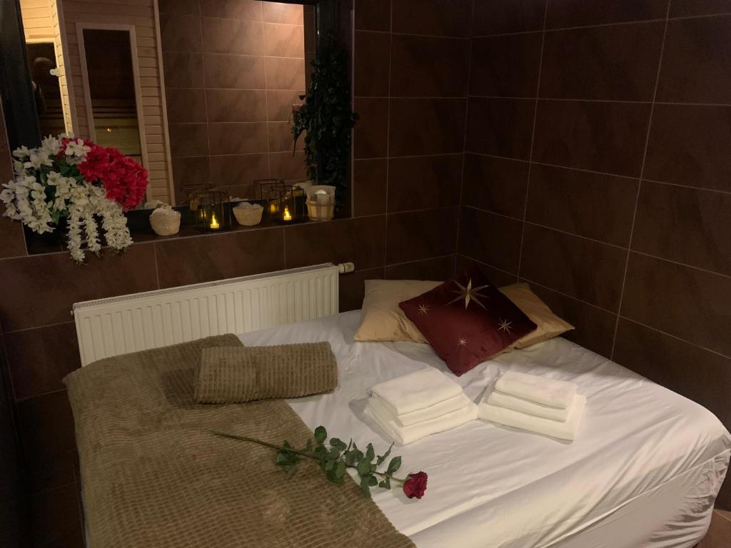 Una cama con sábanas blancas y libros. en Refresh Club wellness, en Poruba