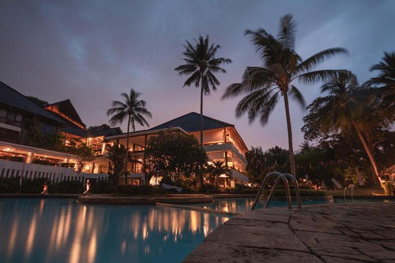 una piscina con palmeras frente a un edificio en المثالي, en Bayt Mi‘yād