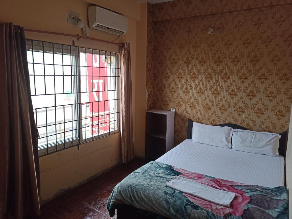een slaapkamer met een groot bed en een raam bij Hotel Opera in Bharatpur
