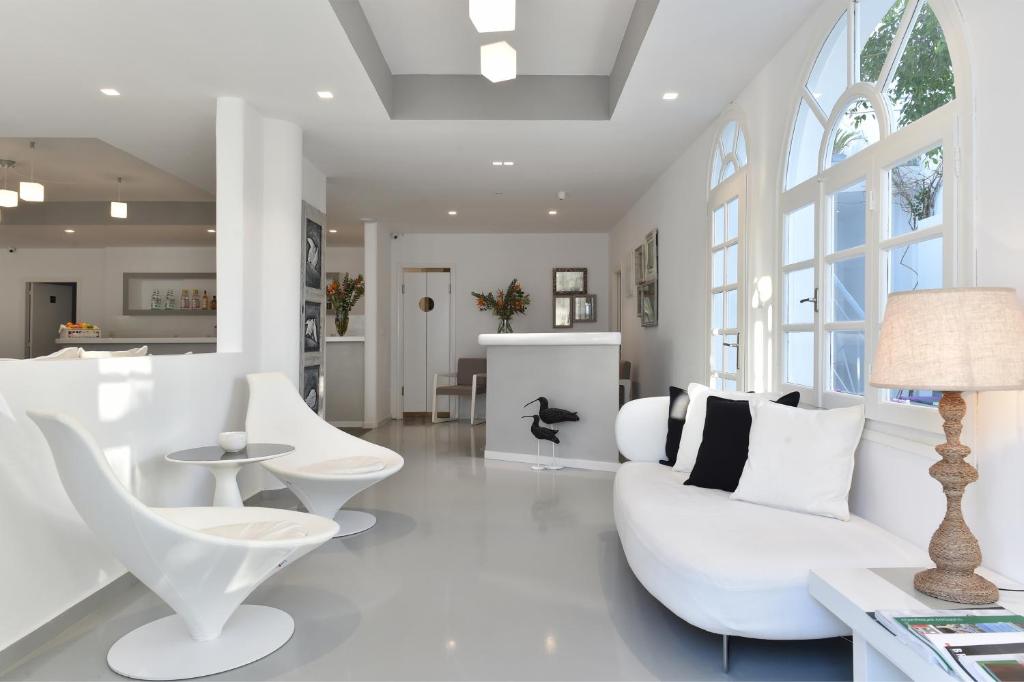 una sala de estar blanca con muebles y ventanas blancos. en Mersina Exclusive, en Naousa