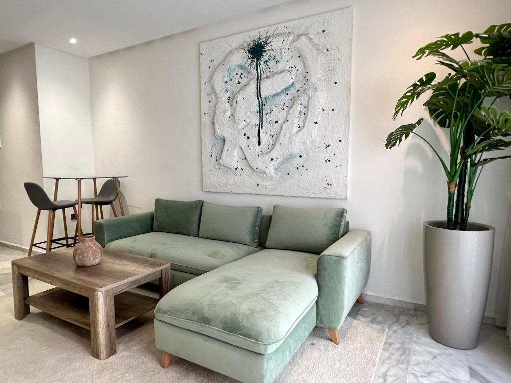 a living room with a green couch and a table at Dynasty Estate - Maarif residency in Casablanca