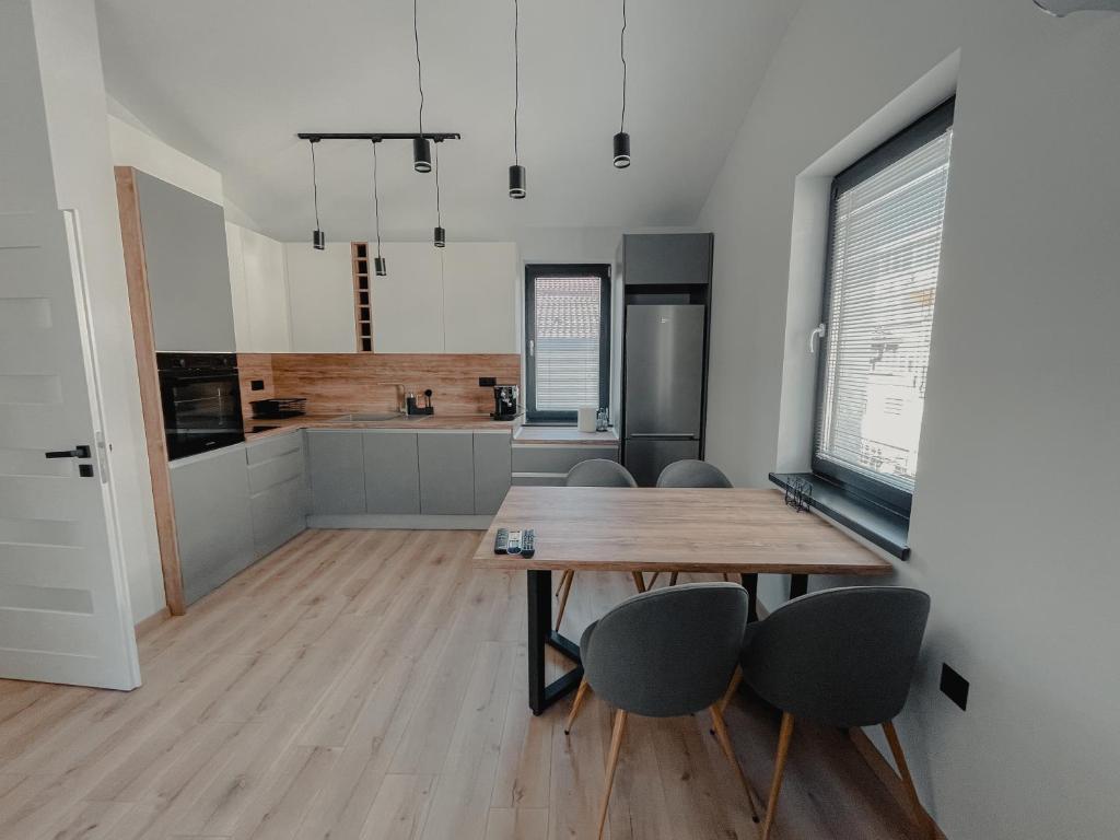 une cuisine et une salle à manger avec une table et des chaises en bois dans l'établissement Hugo, à Varna