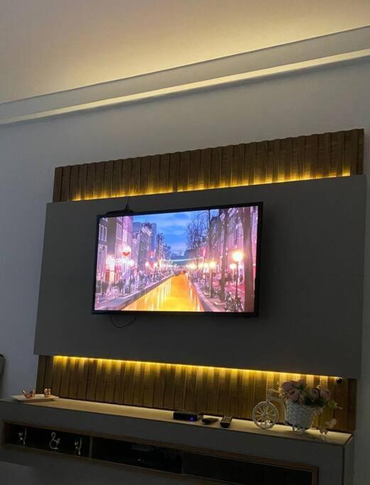 telewizor z płaskim ekranem wiszący na ścianie w obiekcie Apartamento Aconchego condomínio florida w mieście Feira de Santana