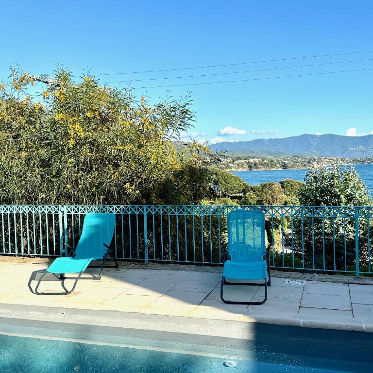 two blue chairs sitting next to a swimming pool at Villa Turquoise Sagone in Sagone