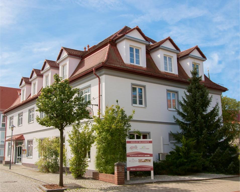 ein großes weißes Haus mit rotem Dach in der Unterkunft Hotel "Zur Mühle" in Hoyerswerda