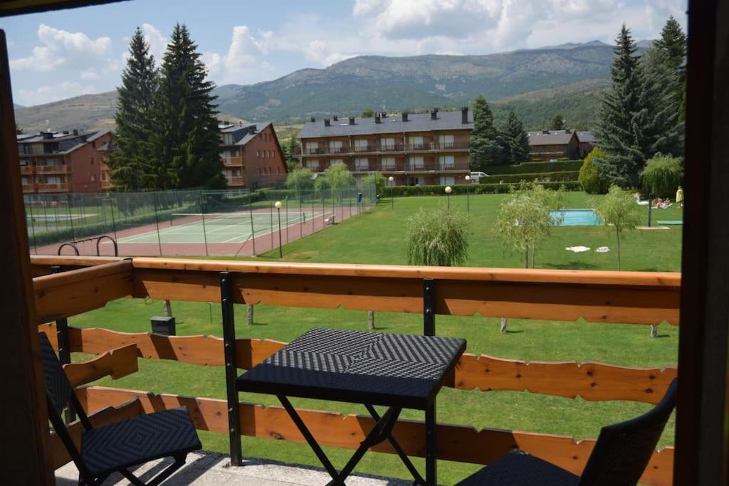 a balcony with two chairs and a tennis court at Ático en Llivia espacioso y acogedor in Llivia