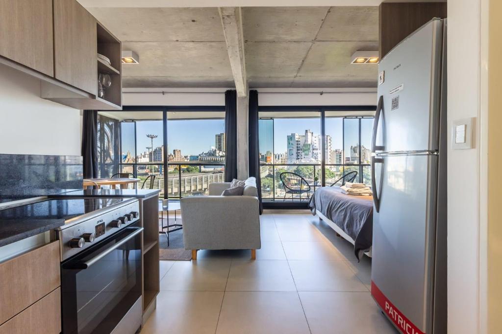 a kitchen with a refrigerator and a living room at Loft Elegante a 5 Minutos de Puerto Madero 6B in Buenos Aires