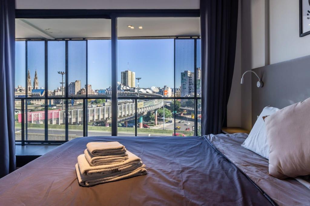 a bed with towels on it in a room with a window at Loft Elegante a 5 Minutos de Puerto Madero 6B in Buenos Aires