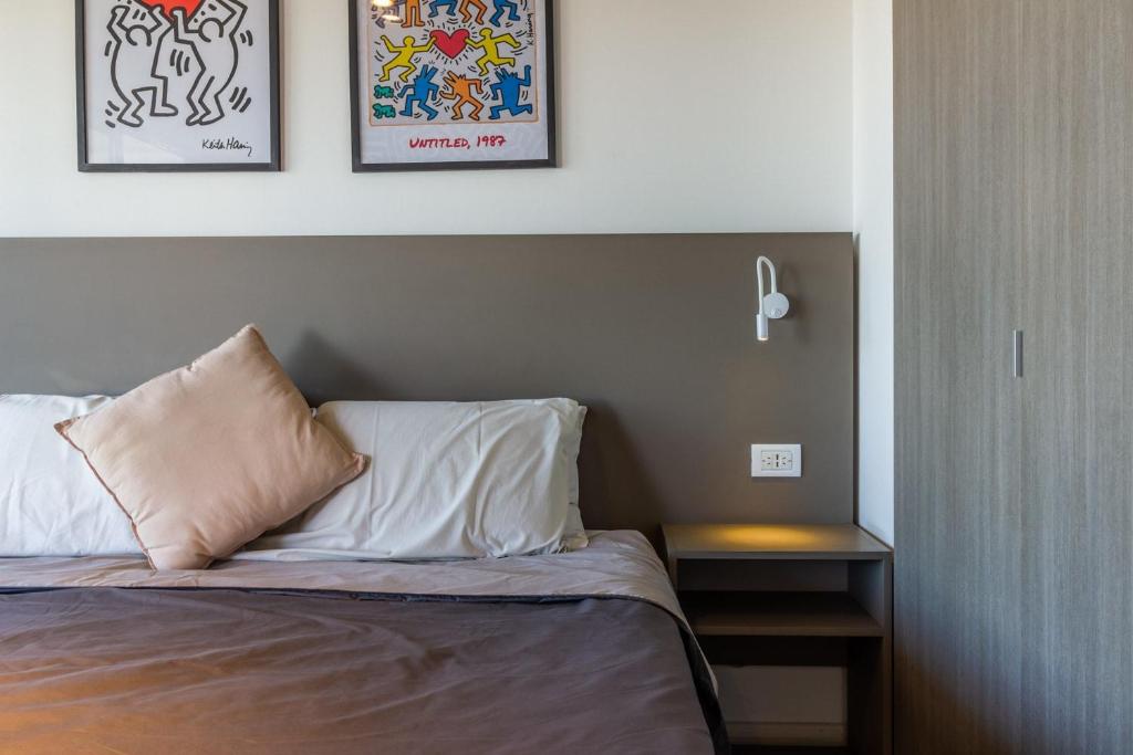 a bedroom with a bed with two pillows and a table at Loft Elegante a 5 Minutos de Puerto Madero 6B in Buenos Aires