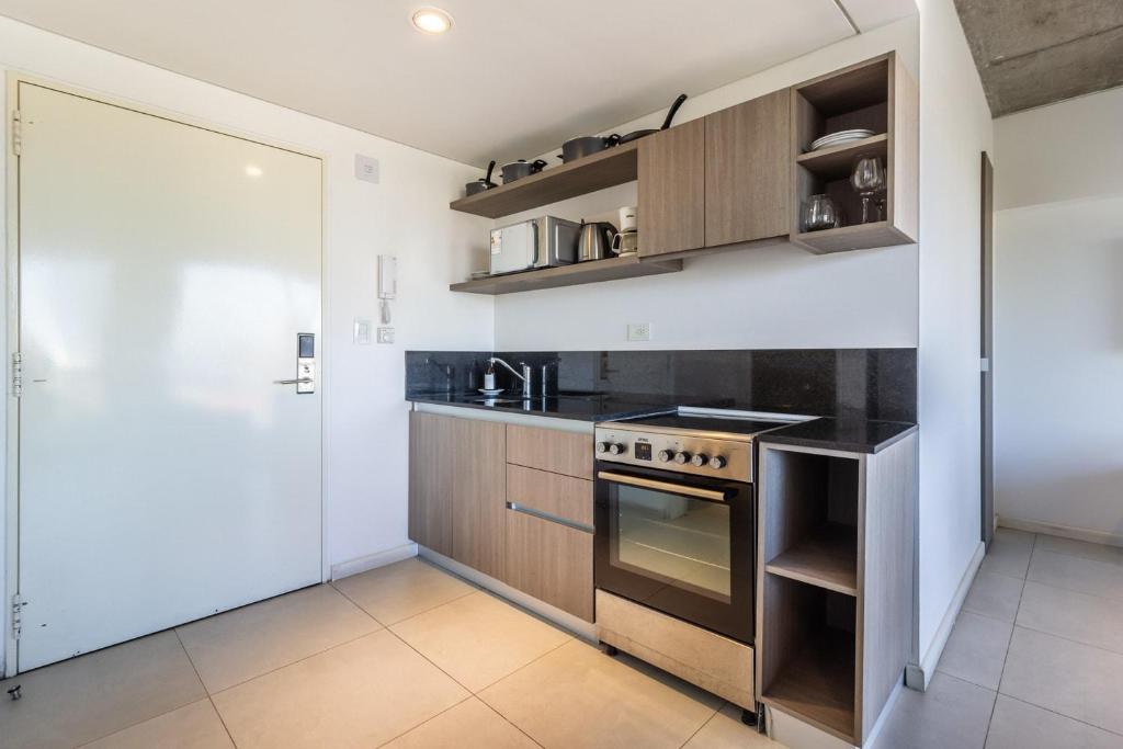 a kitchen with a stove top oven next to a door at Loft Elegante a 5 Minutos de Puerto Madero 6B in Buenos Aires
