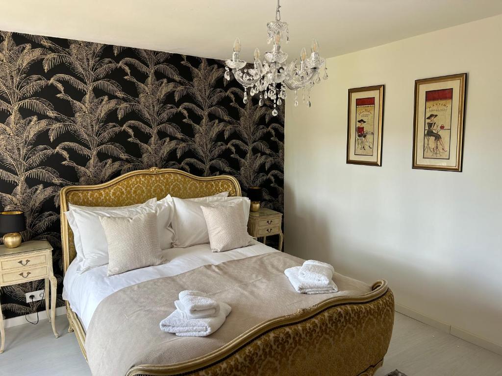 Schlafzimmer mit einem Bett mit einer schwarz-weißen Tapete in der Unterkunft La Maison Mignonne in Azerables