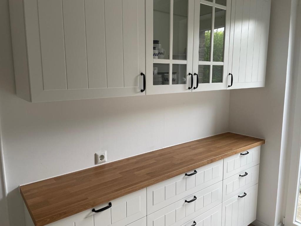 Appartment Königshof في كريفيلد: مطبخ بدولاب بيضاء وقمة كونتر خشبي