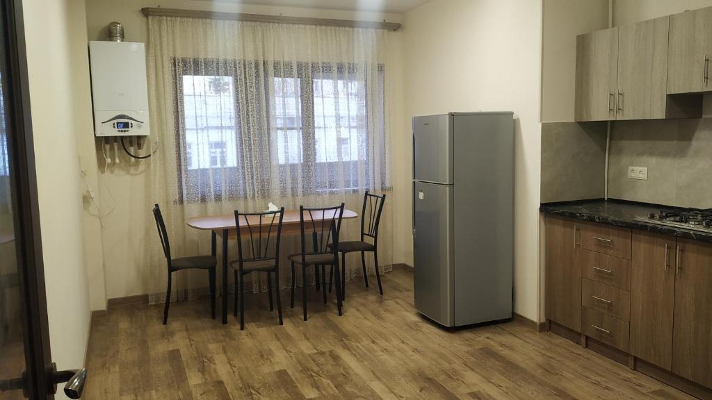 Vanadzor的住宿－Квартира，厨房配有桌椅和冰箱。