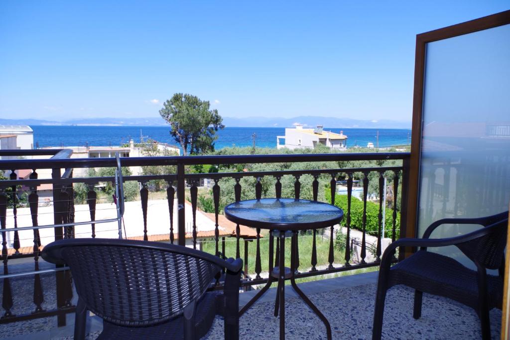 balcón con mesa, sillas y vistas al océano en Sotiras Rooms en Skala Sotiros