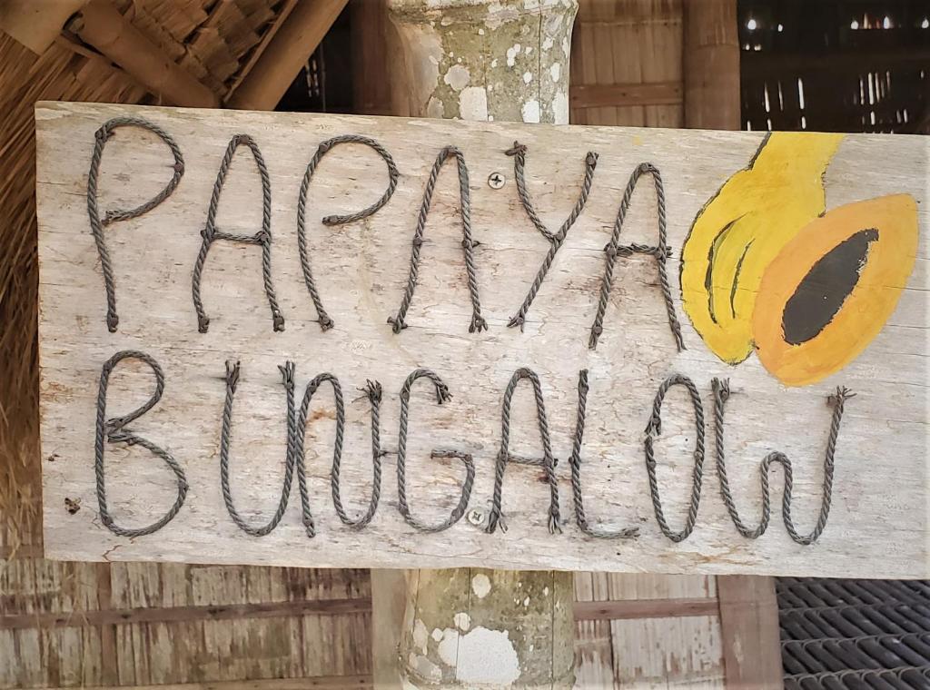 una señal para una panadería de plátanos en un árbol en OBT - The Papaya Bungalow 