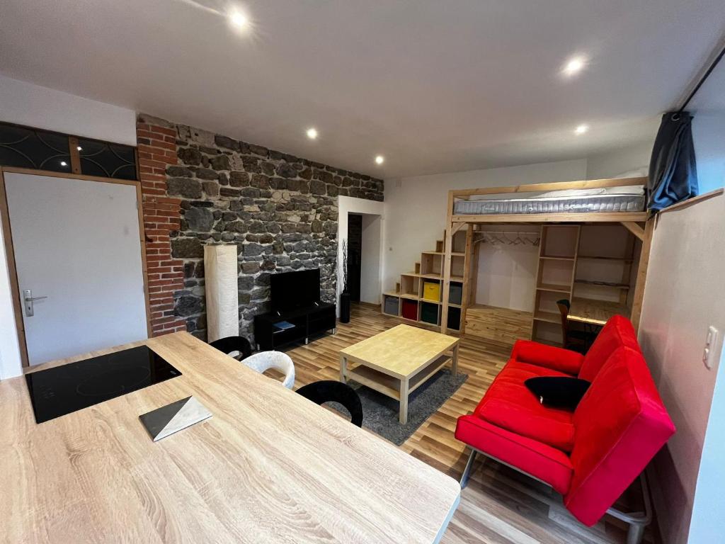 un salon avec un canapé rouge et une table dans l'établissement Studio Dali, au Puy-en-Velay