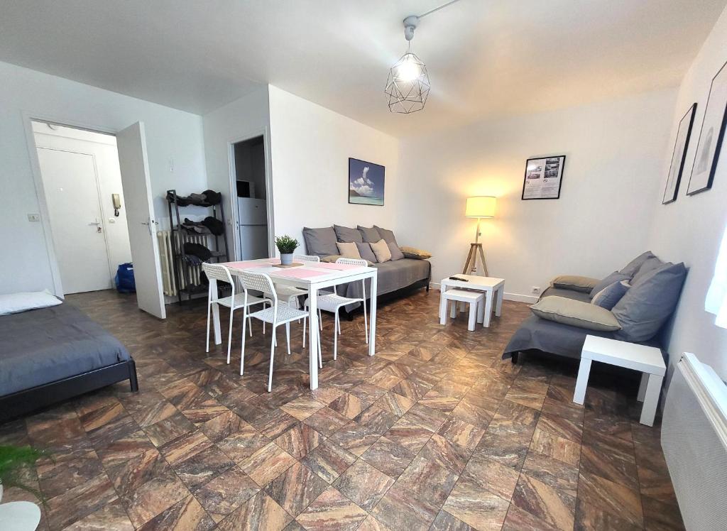 uma sala de estar com uma mesa e um sofá em St-Quentin-en-Yvelines Plusieurs appartements avec parking em Trappes
