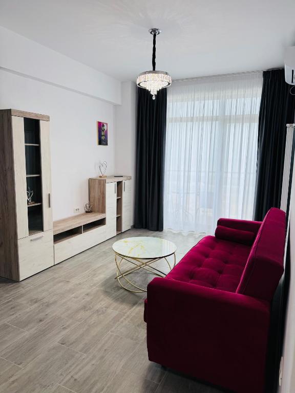 a living room with a red couch and a table at RRed in Năvodari