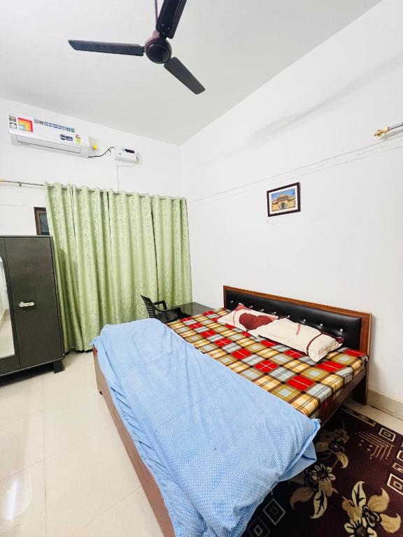 a bedroom with a bed and a ceiling fan at Laxmi Niwas Homestay in Faizābād