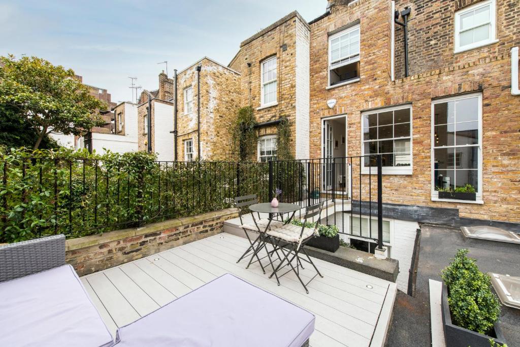 - Balcón con mesa y sillas en un edificio en Delightful Notting Hill 2 bed House with garden, en Londres