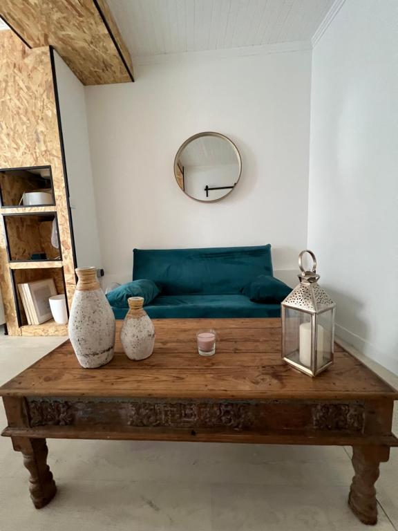 - un salon avec un canapé vert et une table en bois dans l'établissement Cœur, à Palavas-les-Flots