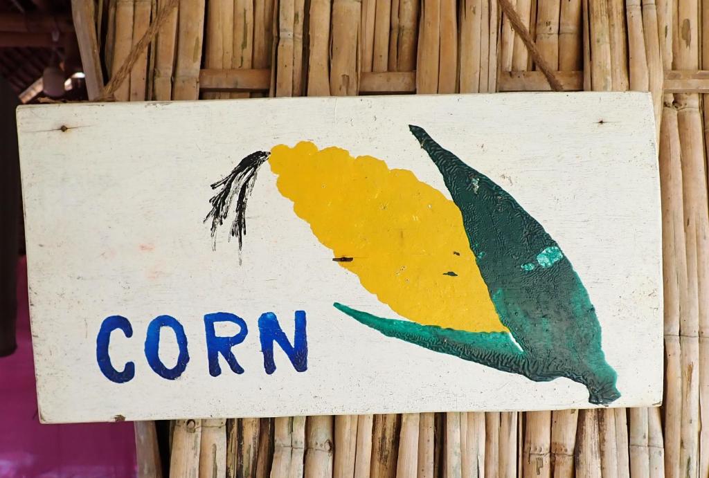 にあるOBT -The Corn Bungalowの竹の壁にトウモロコシの看板