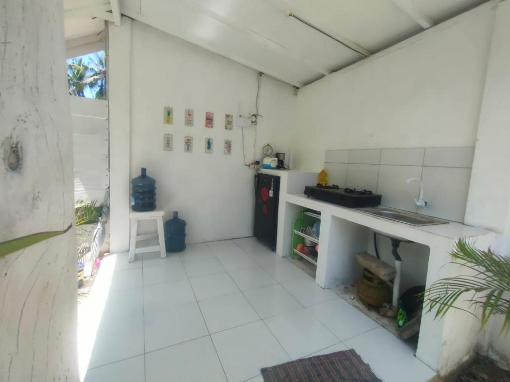 Il comprend une cuisine dotée de carrelage blanc et d'un comptoir. dans l'établissement Balla Naila, à Gili Trawangan