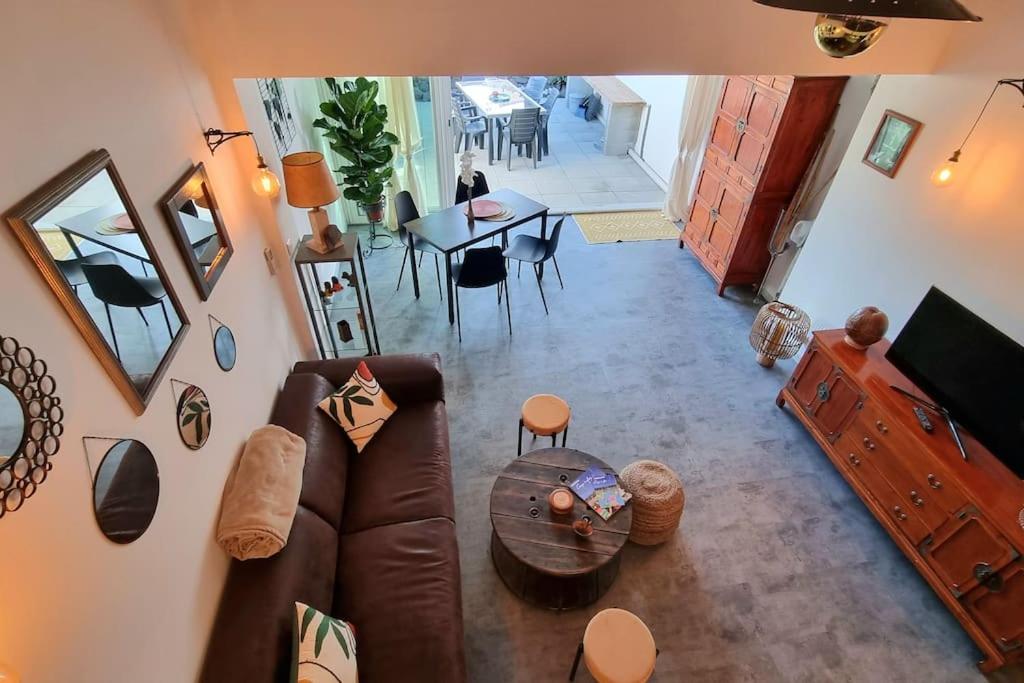 un salon avec un canapé en cuir et une table dans l'établissement Loc Cap Phoebus, atypique, au calme dans la Pinède, au Cap d'Agde