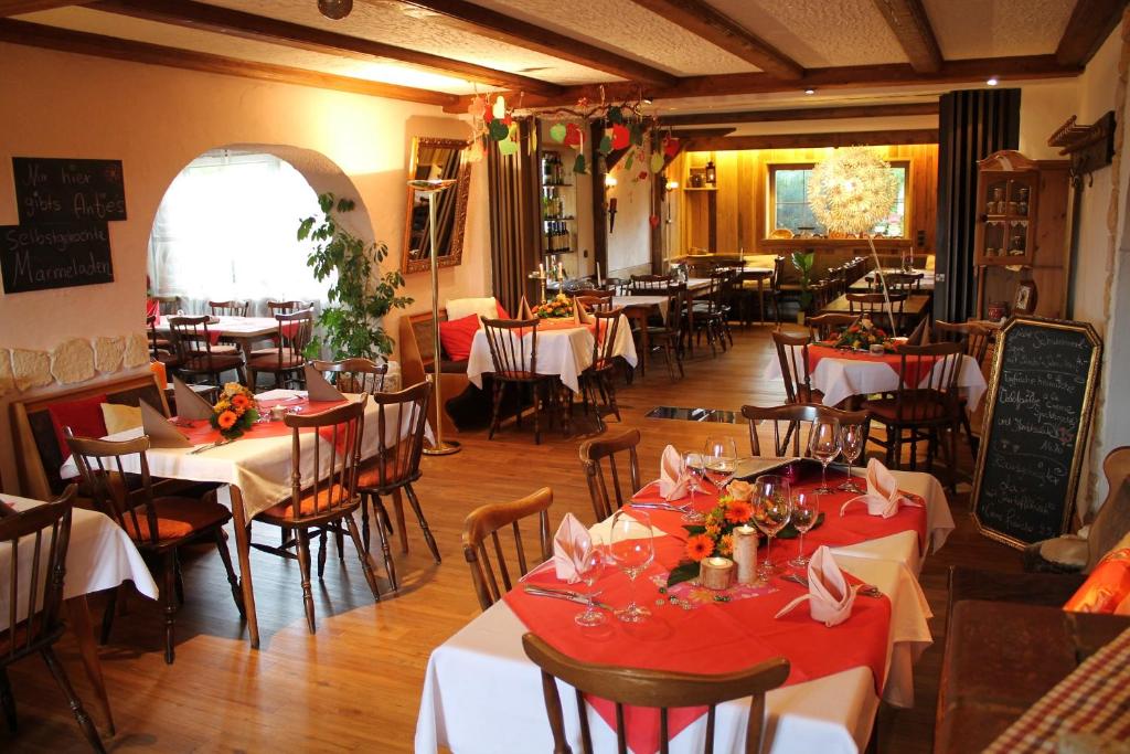 a restaurant with tables and chairs with red tablecloths at Antjes kleines Nest in Tröstau
